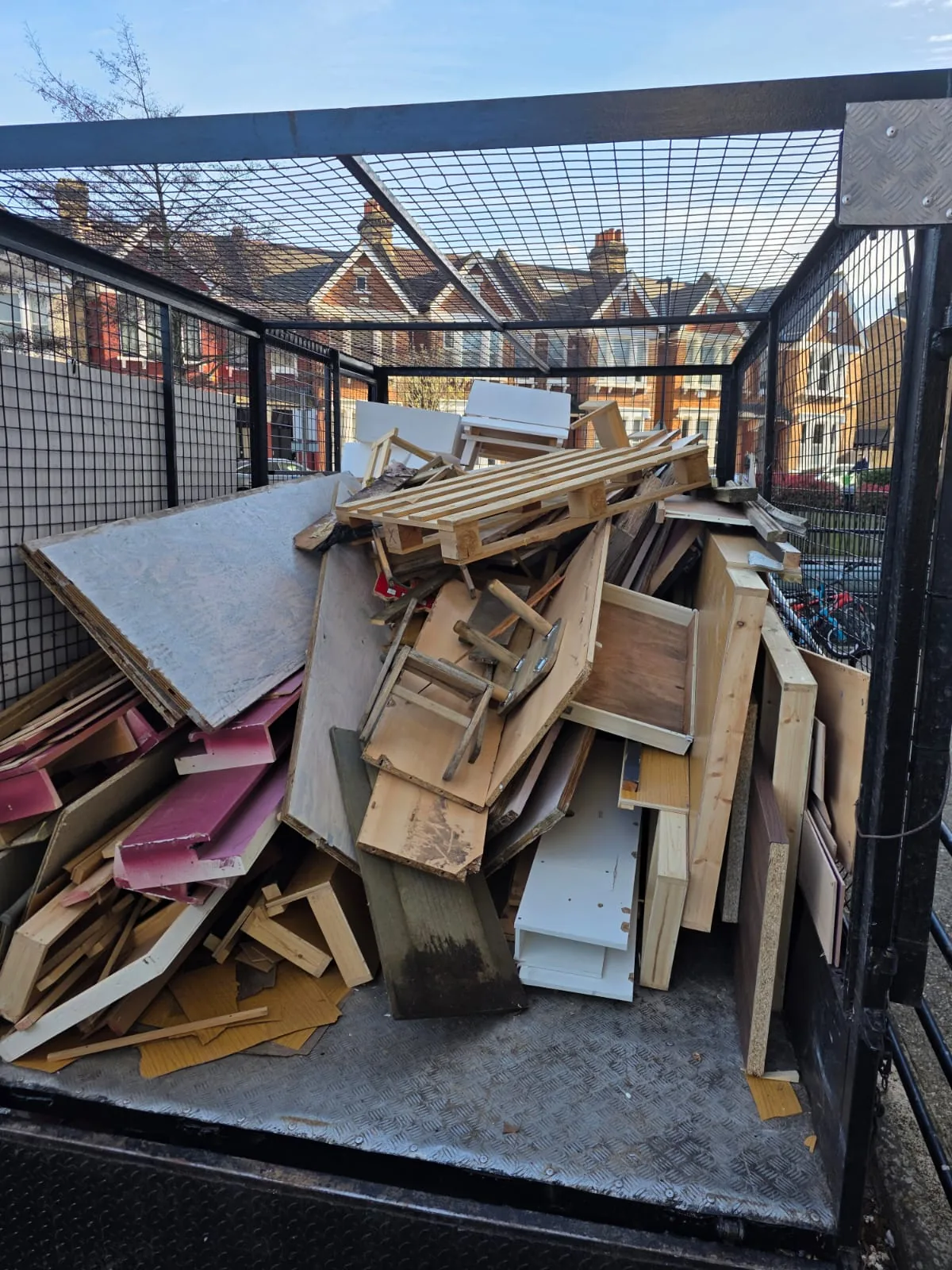 Caged van loaded with timber and board offcuts from a renovation